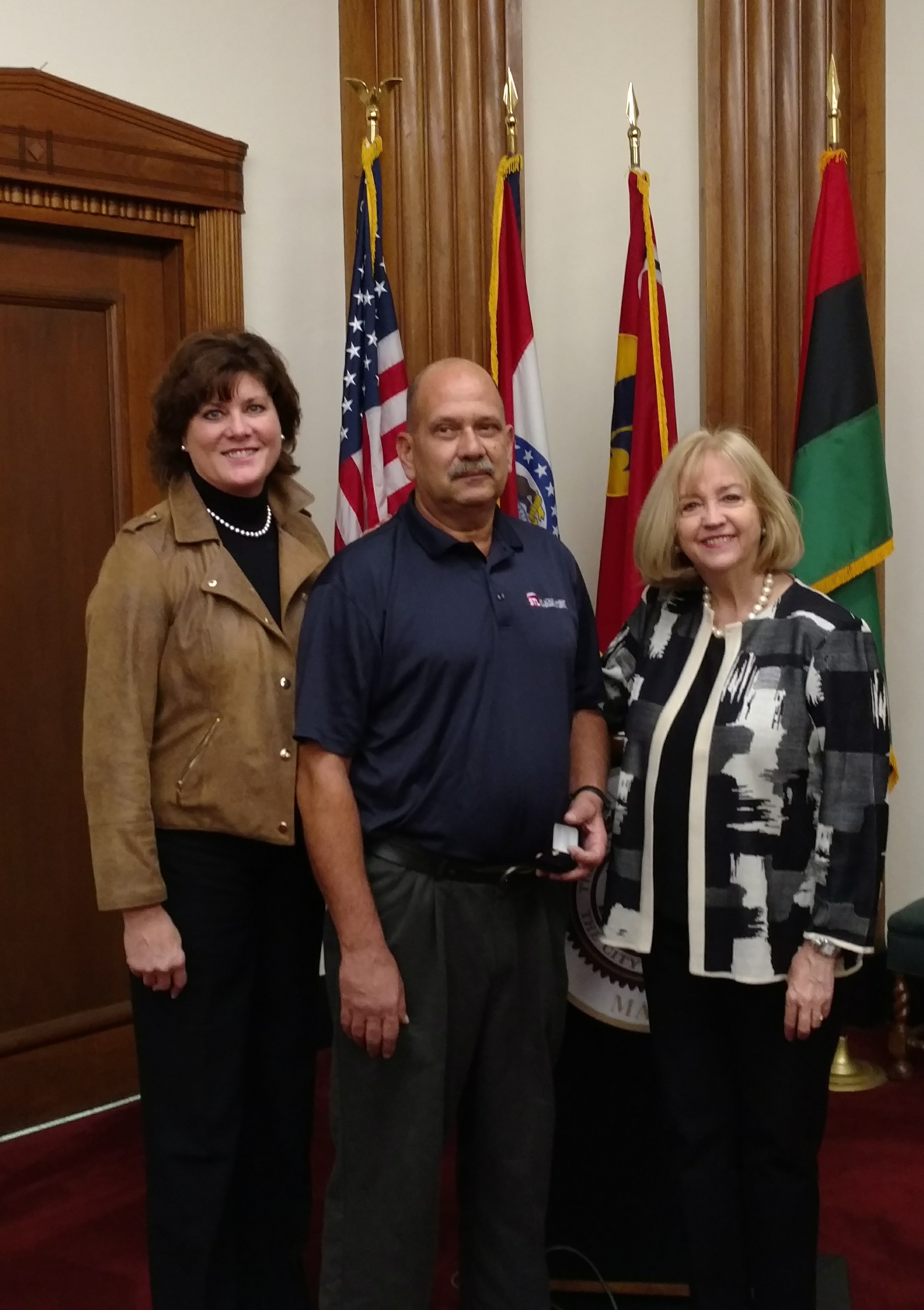 Airport Director Rhonda Hamm-Niebruegge (l) and Mayor Lyda Krewson congratulate Michael Bernich on his 40 years of service with the City of St. Louis