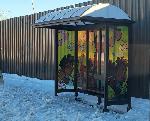 Bus shelter in the snow. Art features a Black woman in the center holding a globe, flowers around her and two Black children on either side of her.