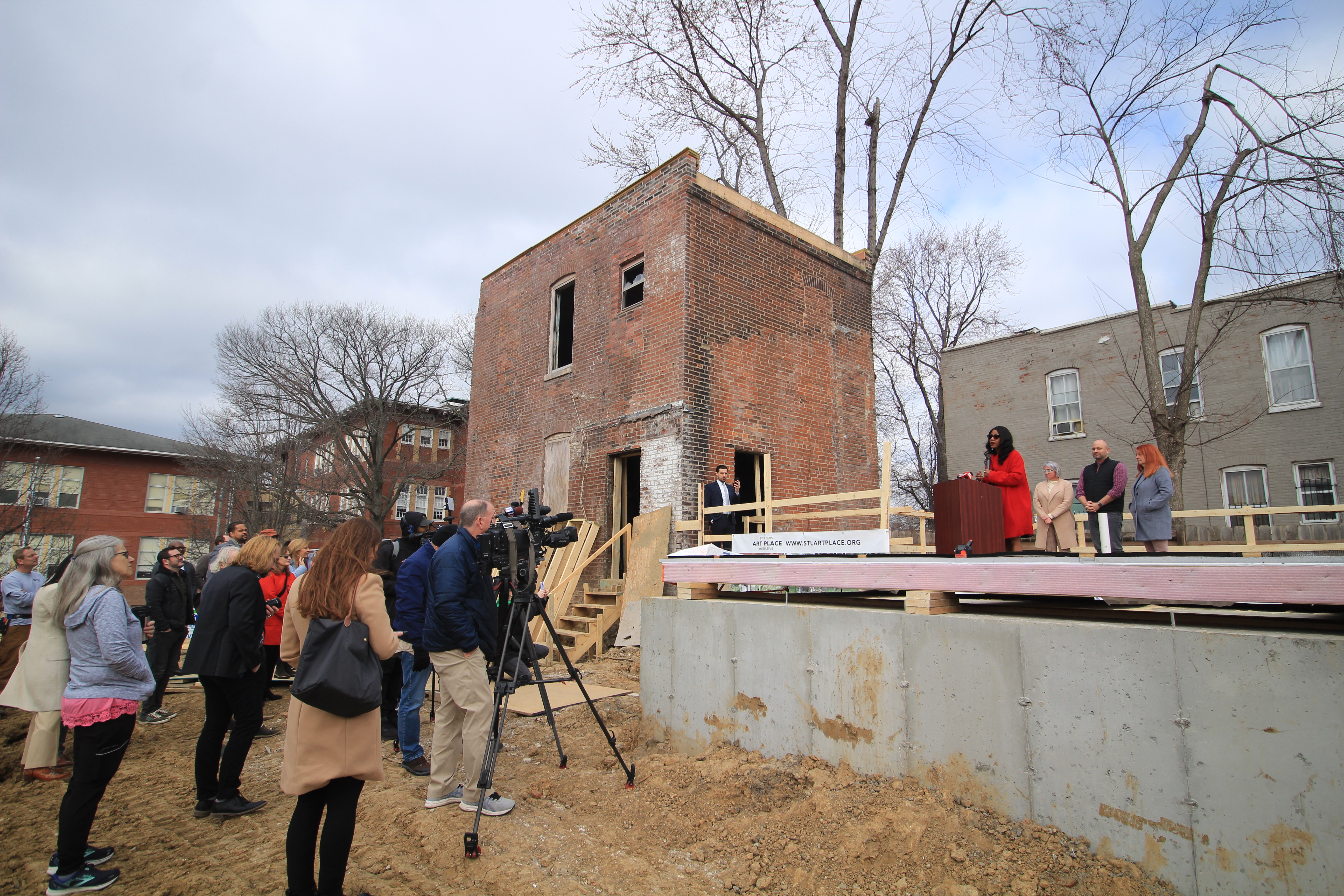 Mayor Jones speaking at vacant house wall raising