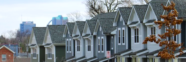 Houses lined up in the Ville with a view of Downtown in winter.