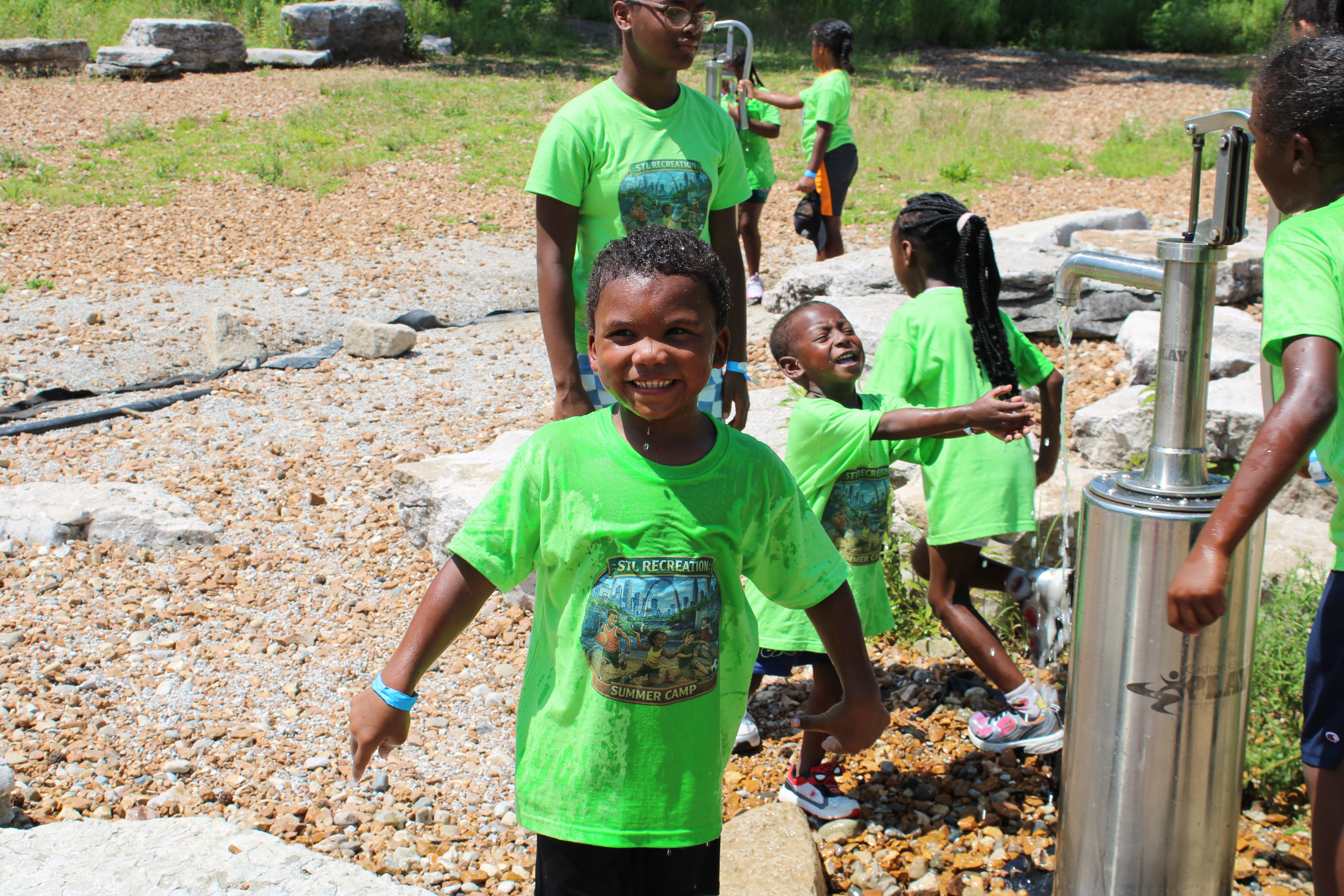 Summer Fun Day student showing excitement playing at Anne O'C. Albrecht Nature Playscape
