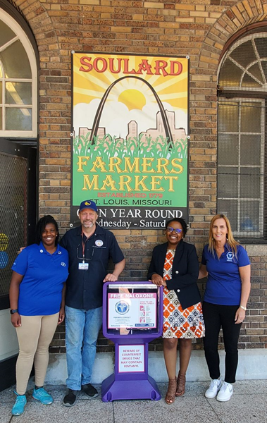 Department of Health staff with Soulard Market Director with a new Narcan box after its installation