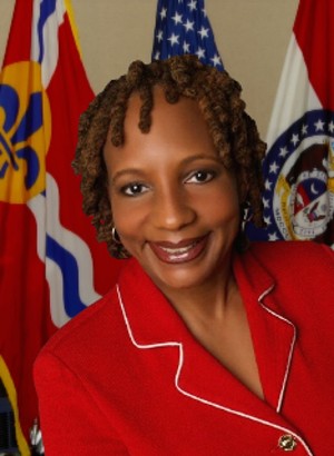 portrait Photo of Mavis Thompson in red with St. Louis Flag in the Background