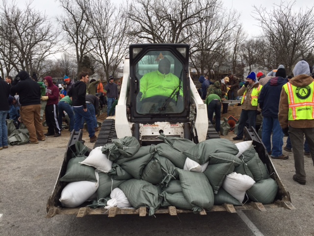 Volunteers load sand bags for the River Des Peres Levee