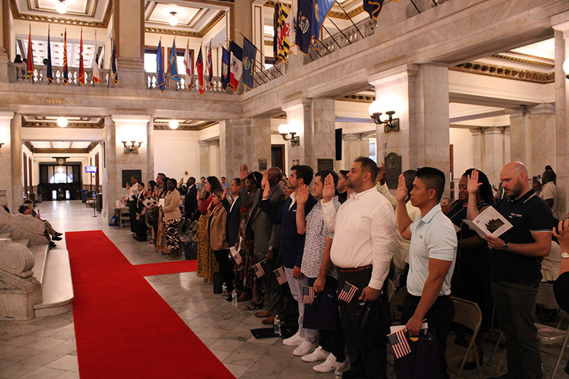 A few dozen people being sworn in as citizens in the City Hall rotunda.