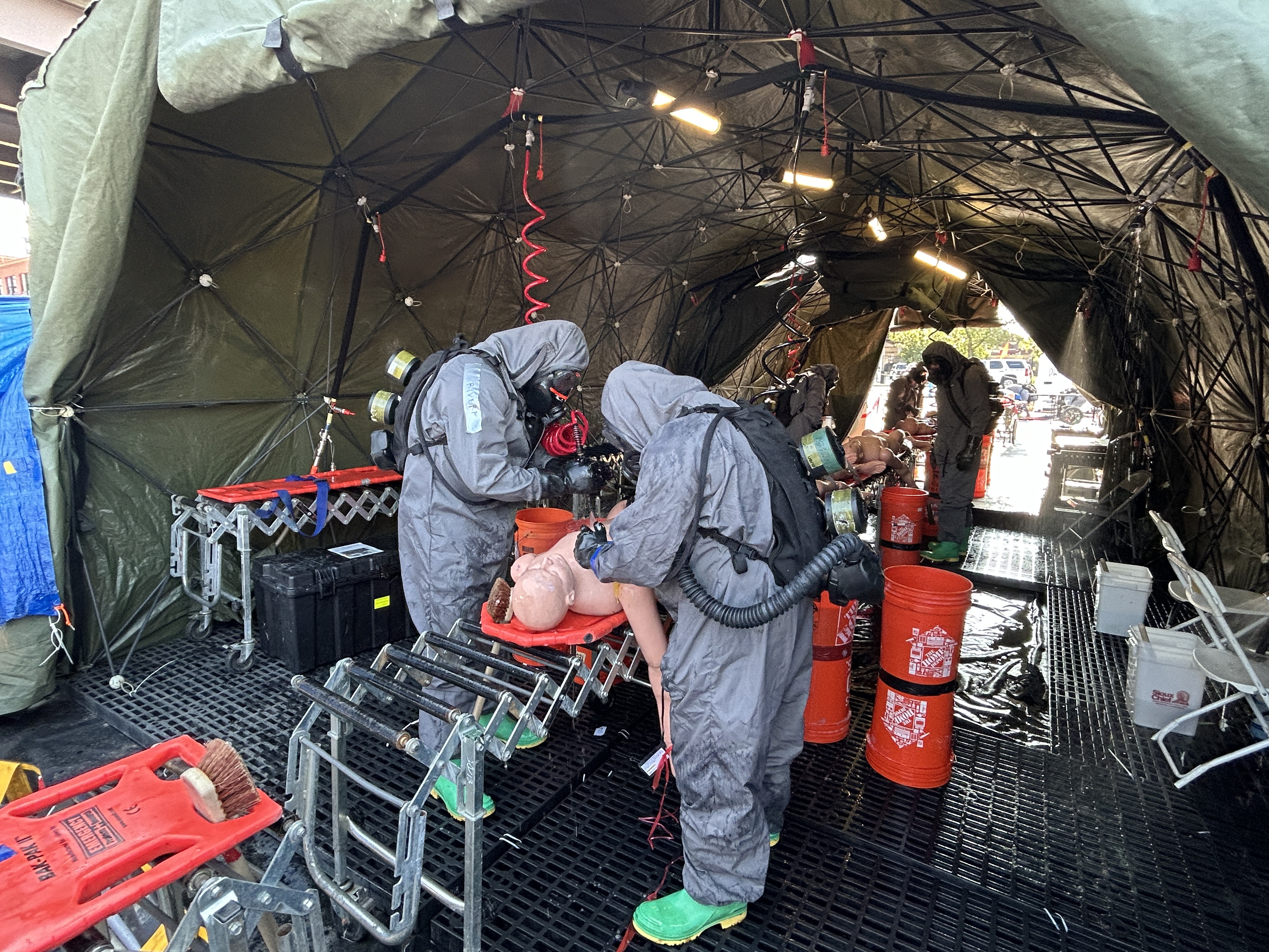 National Guard members use a liquid rinse to practice decontaminate techniques