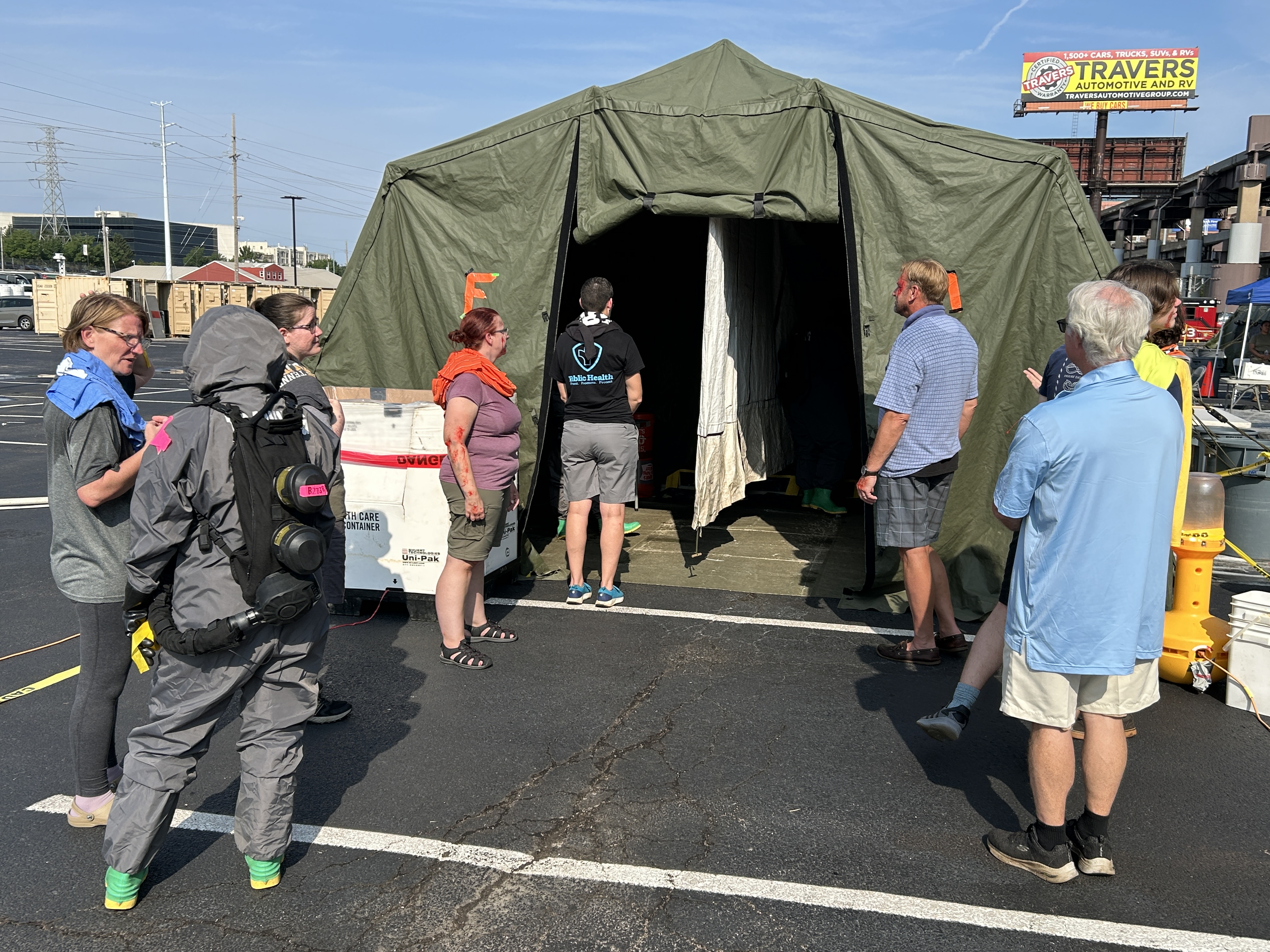 Volunteers prepare to walk through tents for decontamination practice