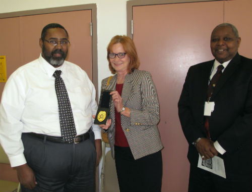 Charlene Deeken presents badge #1 to Dale Glass as Leonard Edwards watches the presentation.