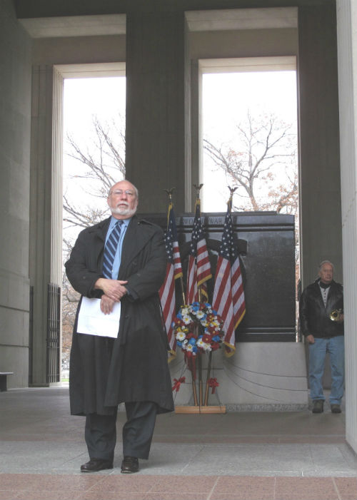 Nelson Mitten makes brief remarks as bugler Stephen Parker looks on.