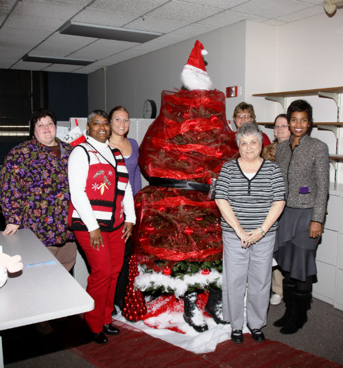 COR staff and contest judges pose by the Santa Claus entry in the 2012 Tree Decorating Contest.