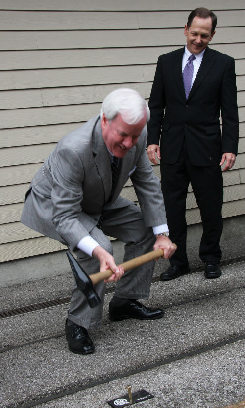 Patrick Sly takes a swing at the golden nail as Mayor Slay watches, during a 50th anniversary celebration of the Emerson Zooline Railroad at the St. Louis Zoo on April 26, 2013.