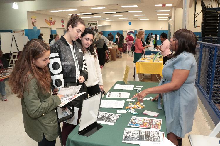 Fair attendees speaking with a vendor.