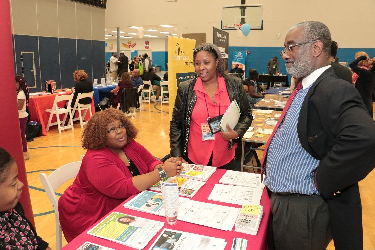 SLATE representatives speaking with fair attendees.
