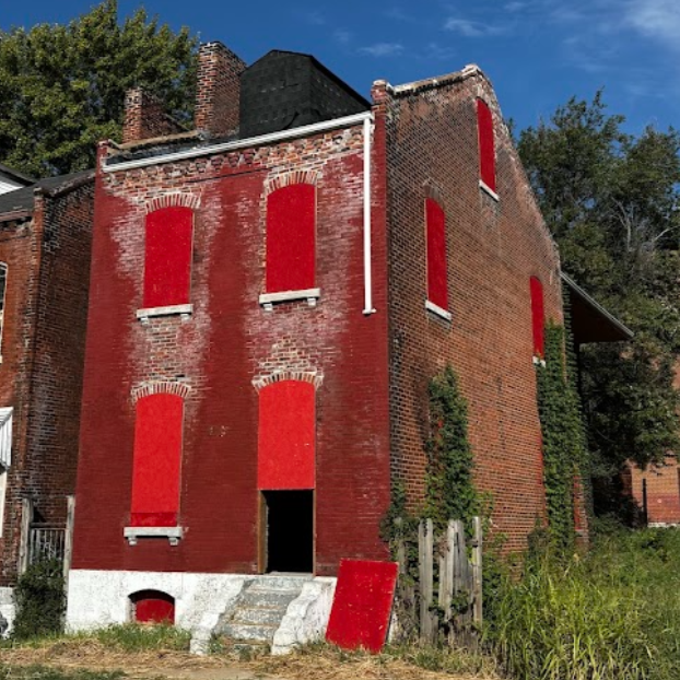 a two-story brick building with boarded-up windows