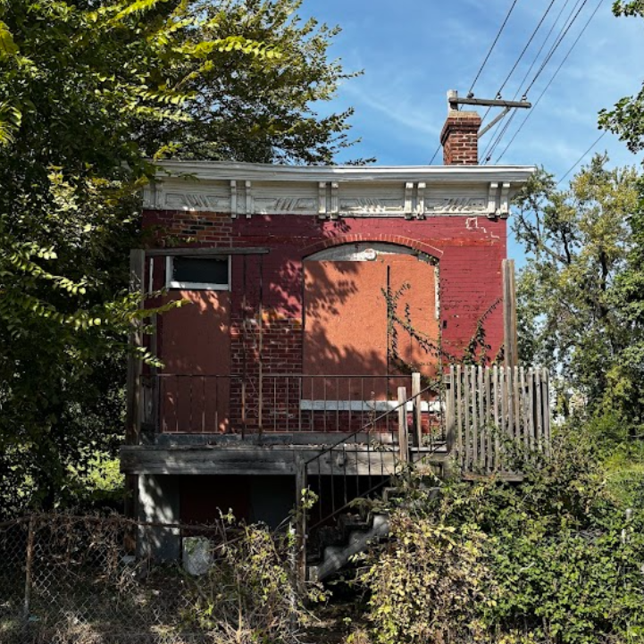 a one-story brick building with boarded-up windows