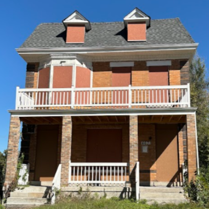 a two-story brick building with boarded-up windows