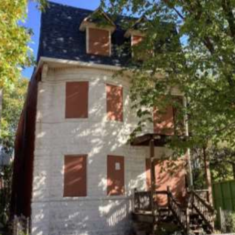 a two-story brick building with boarded-up windows