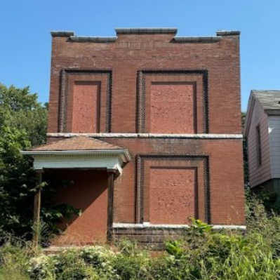 a two-story brick building with boarded-up windows