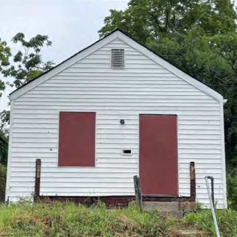 a one-story frame building with boarded-up windows