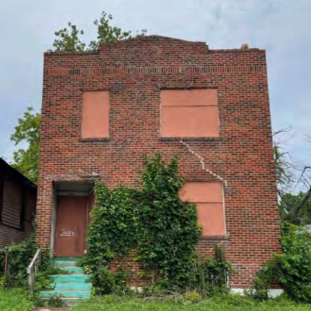 a two-story brick building with boarded-up windows