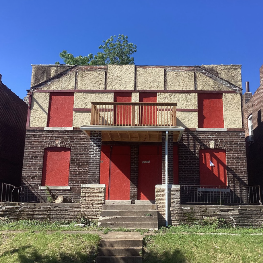 a two-story brick building with boarded-up windows