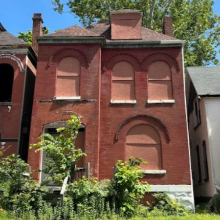 a three-story brick building with boarded-up windows