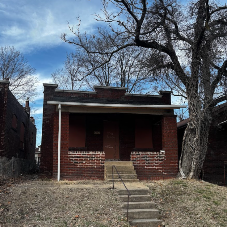 a one-story brick building with boarded-up windows