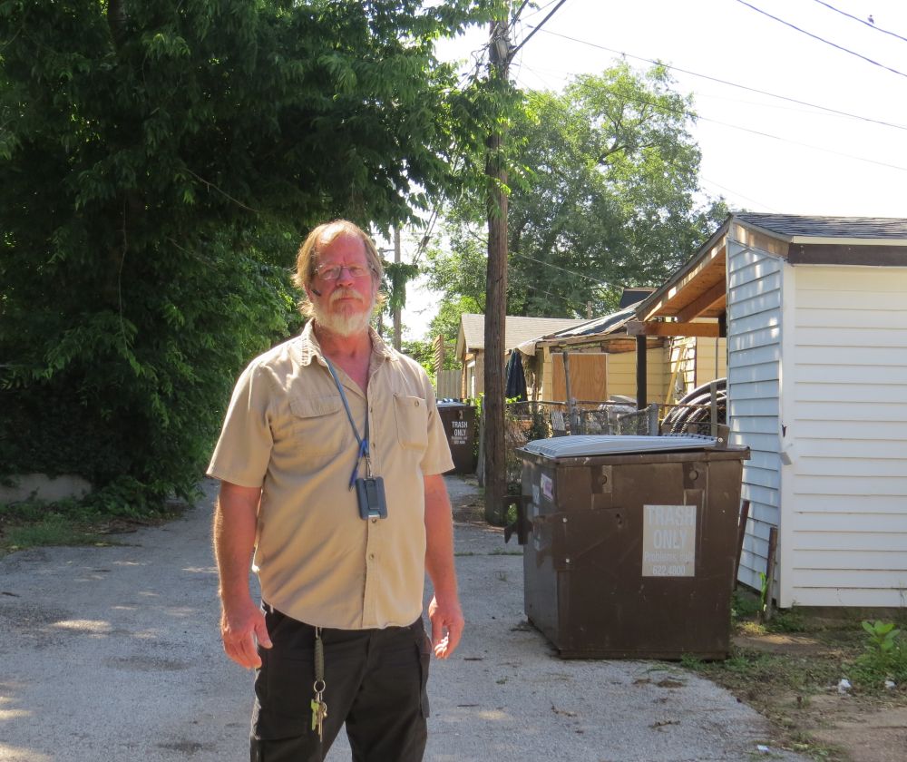 Refuse Division Labor Supervisor standing near trash dumpster
