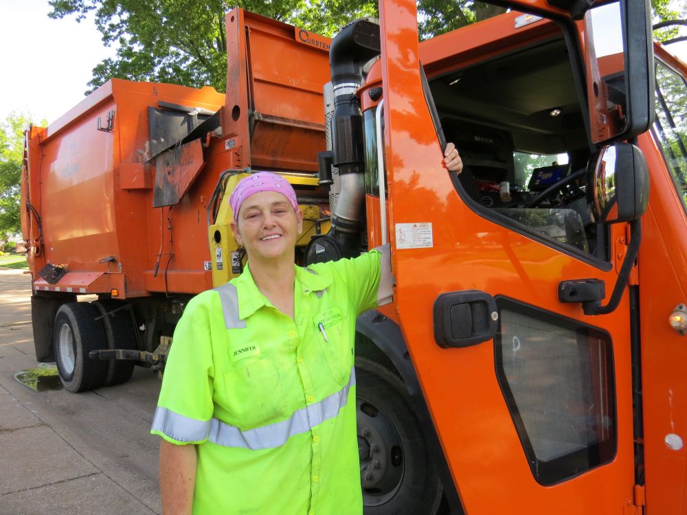 Refuse Division employee standing in front of trash truck