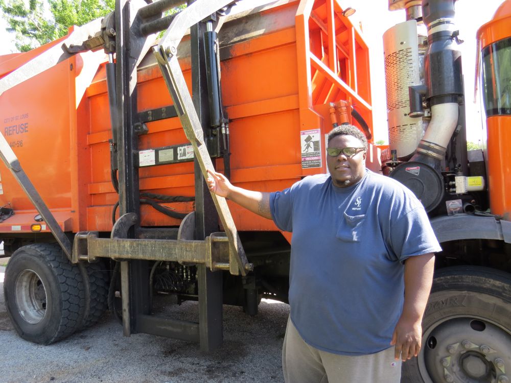 Refuse Division employee standing in front of trash truck