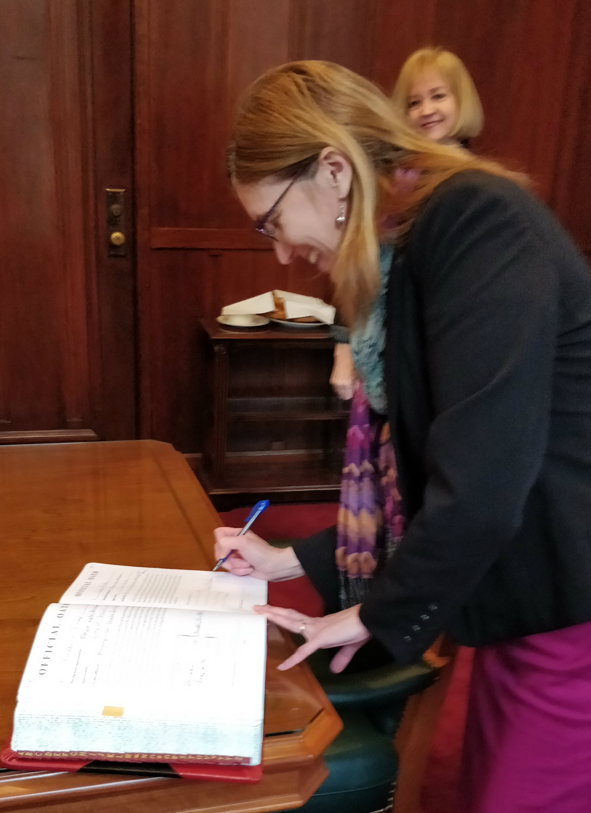 Mayor Lyda Krewson observes Riodan signing the Oath of Office on Dec. 28, 2017.