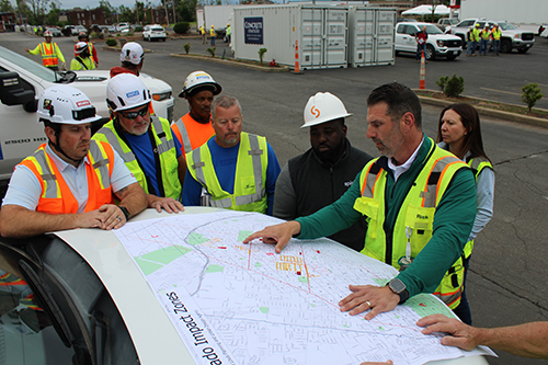 City officials and contractors view a map of the tornado impact zone