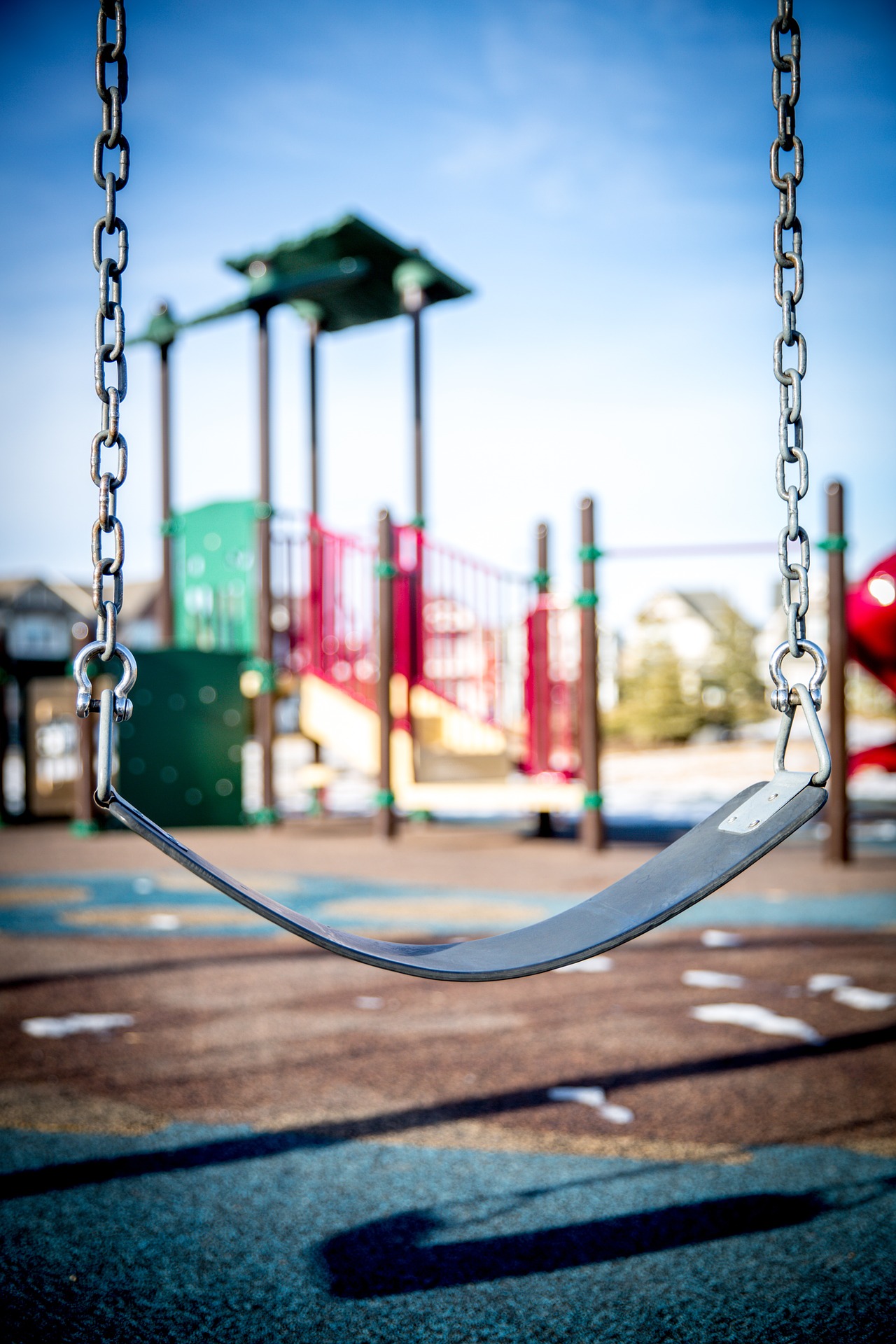 image of a playground through a swing