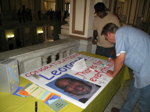 Facilities Management co-workers sign poster at Leonard Harrison retirement celebration